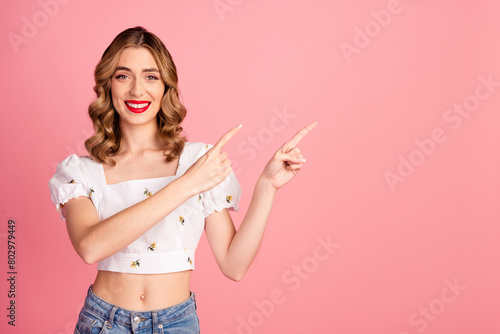 Photo portrait of pretty young girl point empty space wear trendy white outfit hairdo isolated on pink color background