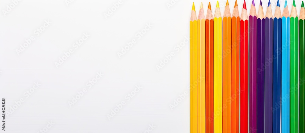A copy space image featuring colored pencils resembling the LGBT flag placed on a white card Adjacent to it is a multicolored paper flag painted in the colors of the LGBT community A copy space image featuring colored pencils resembling the LGBT flag placed on a white card Adjacent to it is a multicolored paper flag painted in the colors of the LGBT community