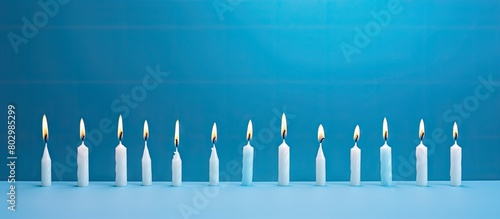 A blue background provides copy space for white and light blue birthday candles