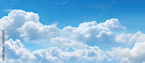 A copy space image showcasing a clear blue sky adorned with fluffy white clouds