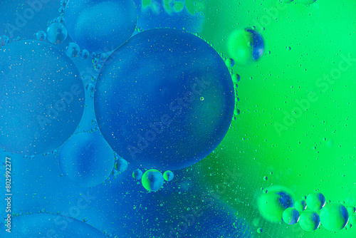 abstract macro background of oil bubbles in water close up in blue and green tones © Mariia