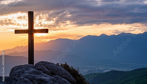  silhouette of awooden cross on a high rock photo