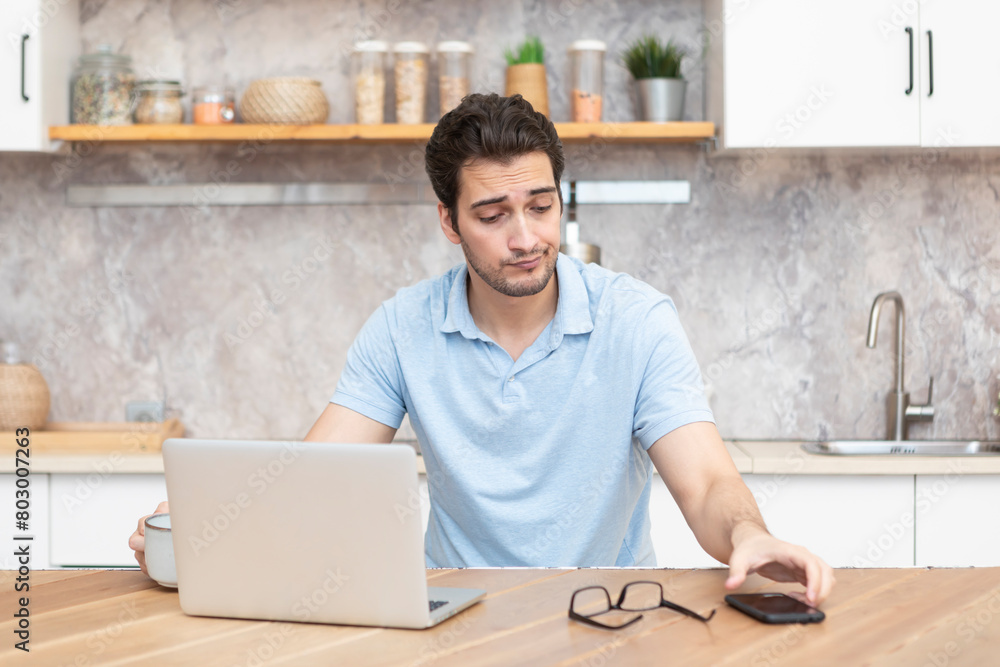 Close up of unhappy man sitting at the table, stressed and confused by calculate expense from invoice or bills, have no money to pay mortgage or loan. High prices and spending money concept Close up of unhappy man sitting at the table, stressed and confused by calculate expense from invoice or bills, have no money to pay mortgage or loan. High prices and spending money concept