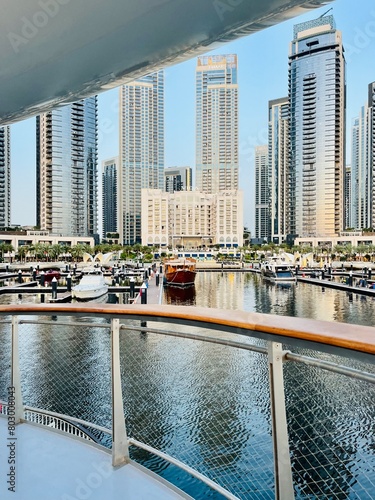 Skyscrapers reflection on the water surface, modern city marina with promenade photo