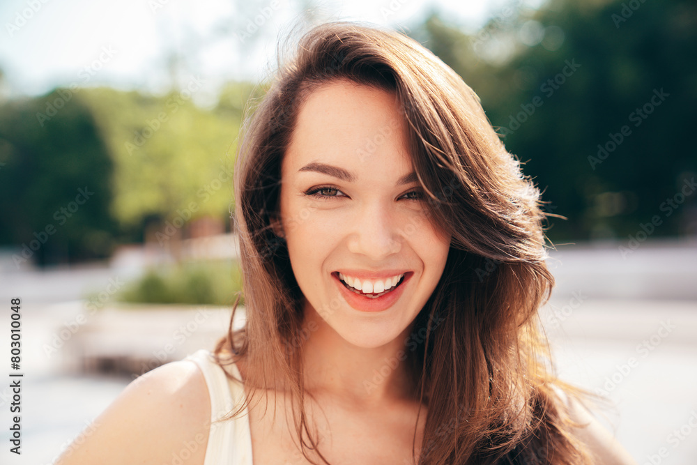 Closeup portrait of young beautiful smiling woman in trendy. Sexy carefree model posing on the street background at sunset. Positive female. Cheerful and happy. Outdoors at sunny day