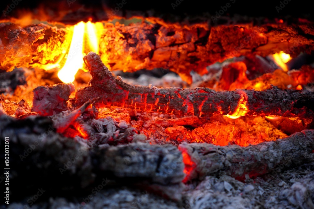 The hot red coals from the campfire are smoldering The hot red coals from the campfire are smoldering