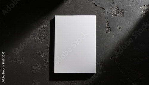 Mock-up of white blank card sheet of paper on black textured surface. Postcard template. Top view.