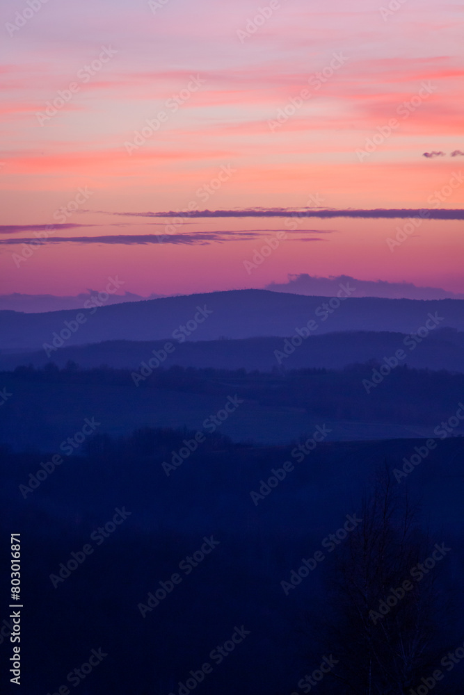 Purple sunset over the hills. Vertical.