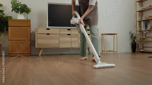 a wife is doing housework, use cleaning tools to make cleaning the floor easier, housekeeper is trying to remove dust on the floor because it is dirty, maintain hygiene within the house photo