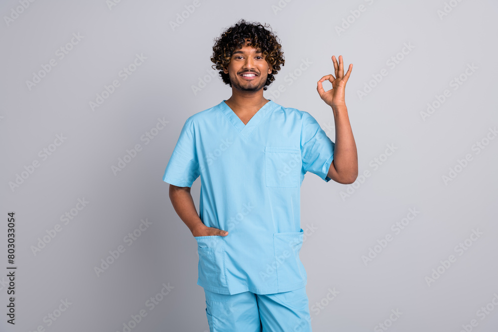 Photo of man doctor make okay symbol isolated grey color background Photo of man doctor make okay symbol isolated grey color background