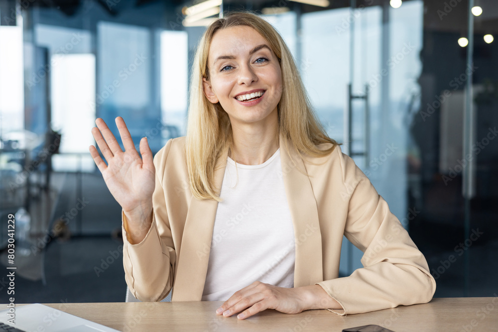 Professional woman in an office greeting with a smile Professional woman in an office greeting with a smile