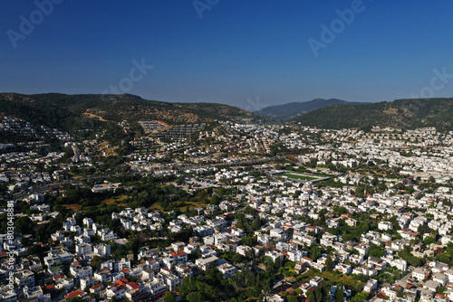 Bodrum city aerial shot. Aegean sea, traditional white houses, flowers, marina, sailing boats, yachts in Bodrum town Turkey. 