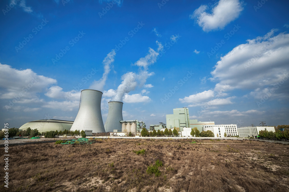 Vast Barren Field with Power Plant Towers and Clear Blue Sky Vast Barren Field with Power Plant Towers and Clear Blue Sky