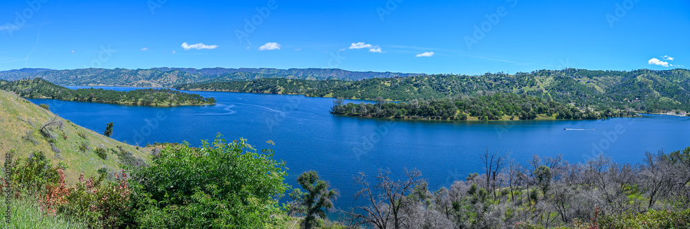 panoramic landscape with lake and mountains blue sky with some white cloud  