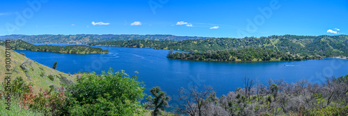 panoramic landscape with lake and mountains blue sky with some white cloud 