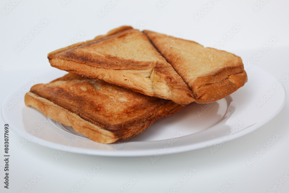 Some toasts or toasted breads, on white plate, isolated on white background