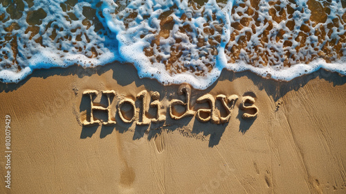 Holidays written on the sand by the sea