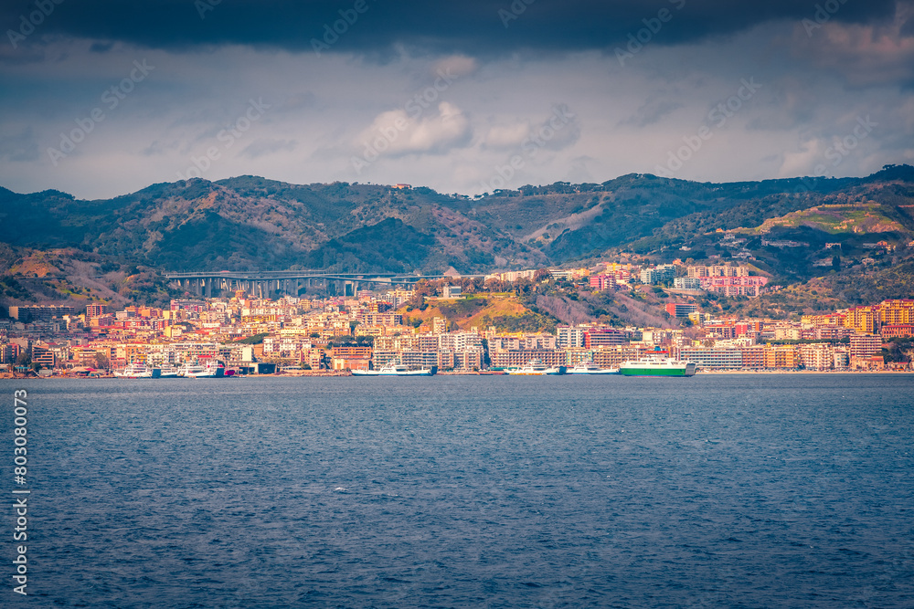 Dramatic morning cityscape of Messina port with old colorful buildings, Sicily, Italy, Europe. Wonderful summer seascape of Mediterranean sea. Traveling concept background.