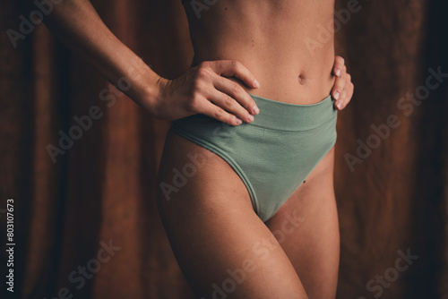 Closeup no retouch photo of woman khaki panties touch waist selflove concept touching small size abdomen isolated on brown color background