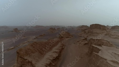 Flying with a drone above the yardangs and natural rock clefts in the Lut plain  High resolution and quality aerial footage. photo