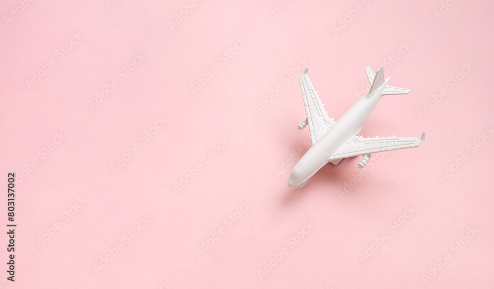 Airplane with passport and tickets on the bright sunny pink background. Vacation travel concept.	Copy space
