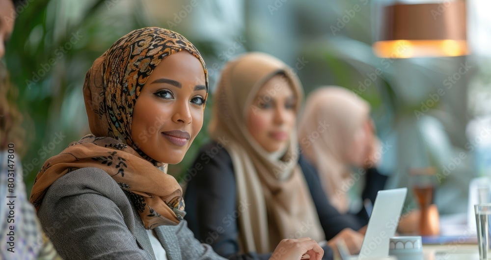 Obraz premium A woman wearing a scarf and a black jacket is smiling in the office. Business