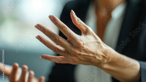 Close-up of a businesswoman's expressive hand gestures during a silent communication training session