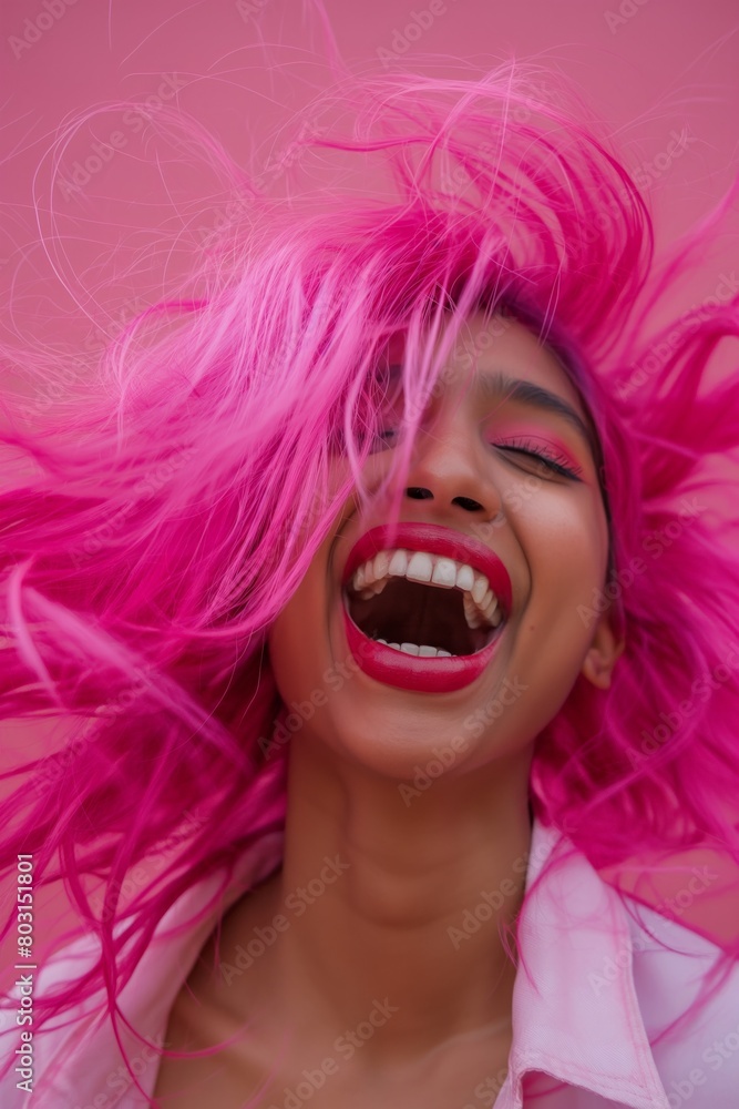 Joyful Indian woman with vibrant pink hair laughing heartily Joyful Indian woman with vibrant pink hair laughing heartily