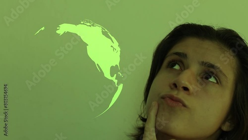 Woman thinking how she could help the planet. Earth planet icon spinning on the side of a thinkful woman. photo