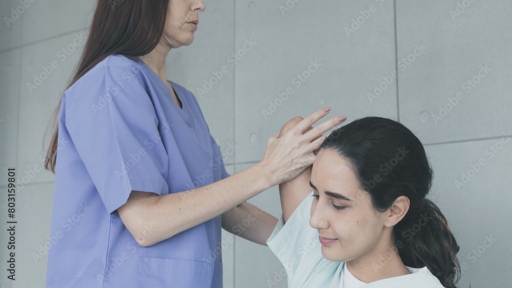 Obraz premium Doctor doing physical therapy on young female patient from office syndrome