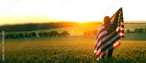 Independence Day. Beautiful girl with the American flag in a wheat field at sunset. 4th of July. Patriotic holiday, american day.