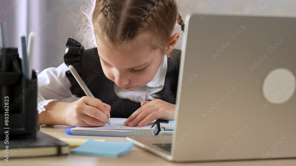 School girl studying online with laptop and notebook at home, close-up School girl studying online with laptop and notebook at home, close-up