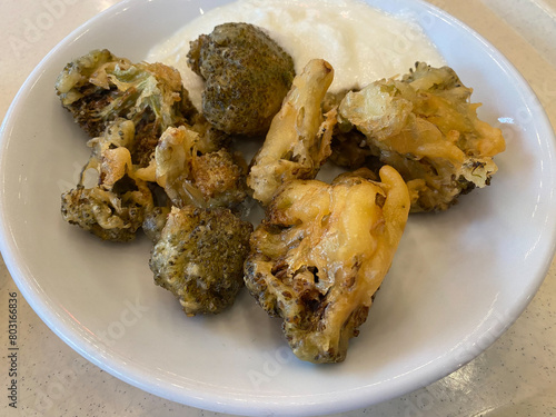 Fried Crisy Broccoli Bites in Batter with Yoghurt.
