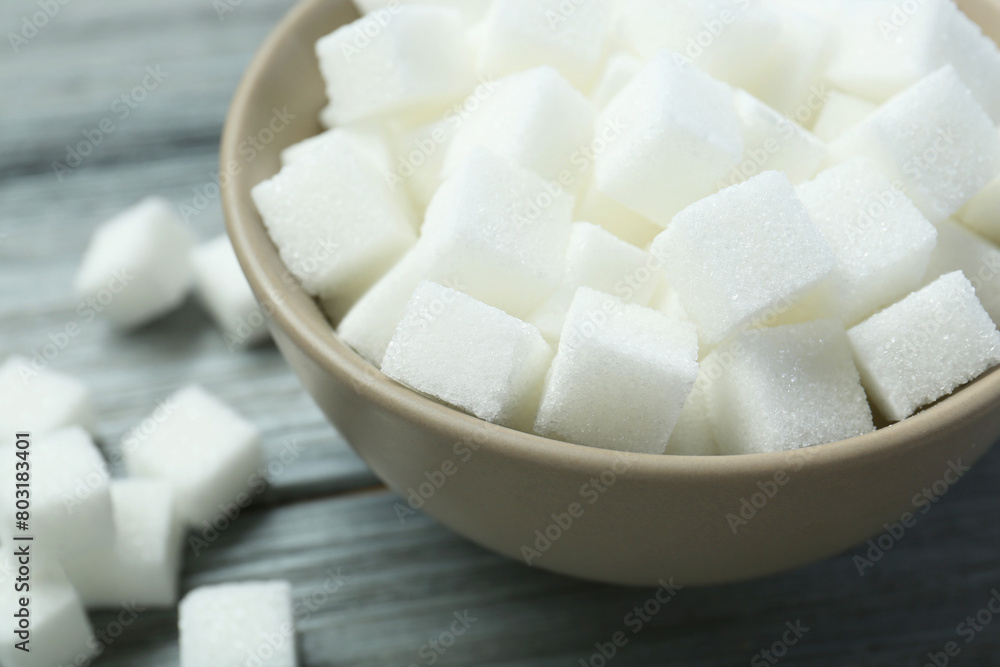 White sugar cubes in bowl on wooden table, closeup White sugar cubes in bowl on wooden table, closeup