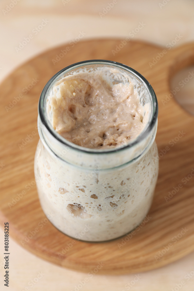 Sourdough starter in glass jar on table, closeup Sourdough starter in glass jar on table, closeup