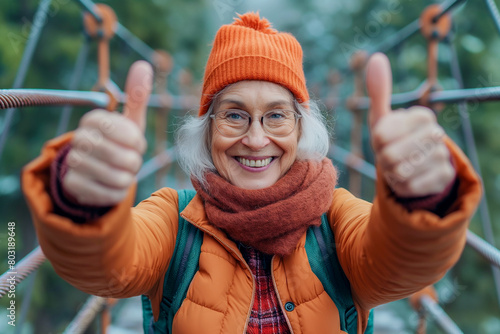 Smiling senior woman showing thumbs up while standing on footbridge.