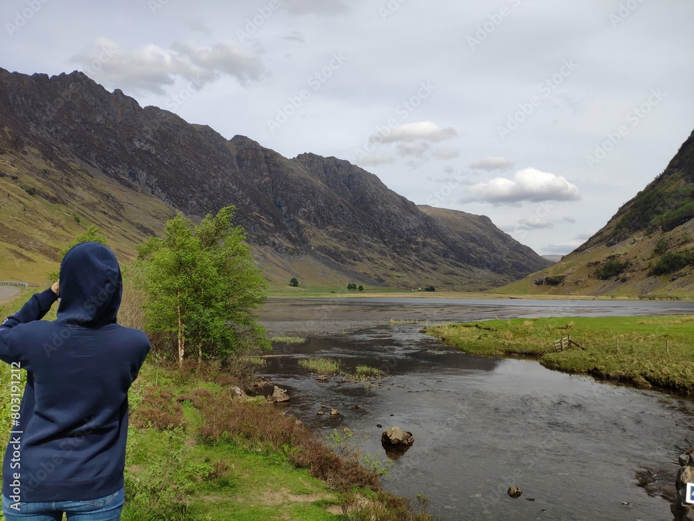 Scottish highland nature scenery, mountain top surrounded by clouds, grazing in streams and rivers, sheep grazing, red bridge across the river Scottish highland nature scenery, mountain top surrounded by clouds, grazing in streams and rivers, sheep grazing, red bridge across the river
