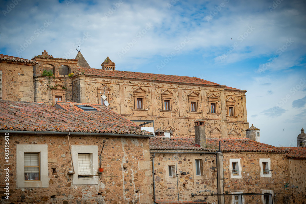 Vista panorámica  del casco histórico de la ciudad española de Cáceres con vistas a los tejados de tejas marrones de edificios antiguos alrededor de la plaza principal en el soleado día de primavera, 