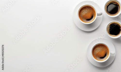 Top view of three white cups of coffee on white background with copy space