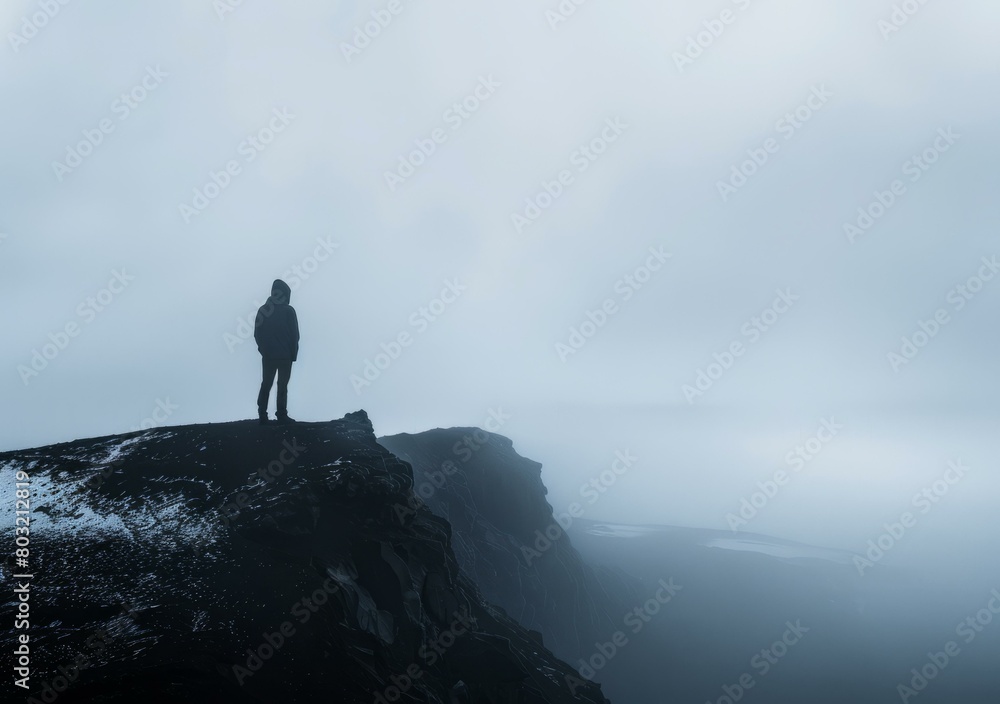 Man standing on a cliff looking out at the ocean