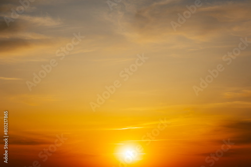Majestic dusk. Beautiful warm blue sky with vivid golden shades. Dense clouds in twilight orange sky. Cloudy bright sky on evening time. Abstract nature background