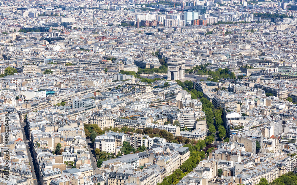 Panoramic view of the roofs of buildings in the center of Paris and the Arc de Triomphe de l'Étoile monument. Tour Eiffel, France.