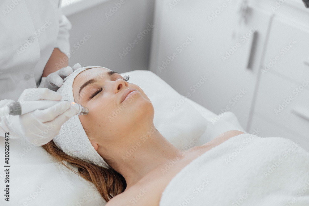 Beautician uses RF lifting to improve skin tone and tighten contour face. This safe and effective method uses radio frequency waves to stimulate collagen and elastin, improving skin structure and
