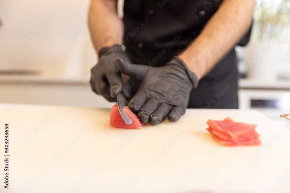 Chef, wearing gloves, preparing nigiri sushi Chef, wearing gloves, preparing nigiri sushi