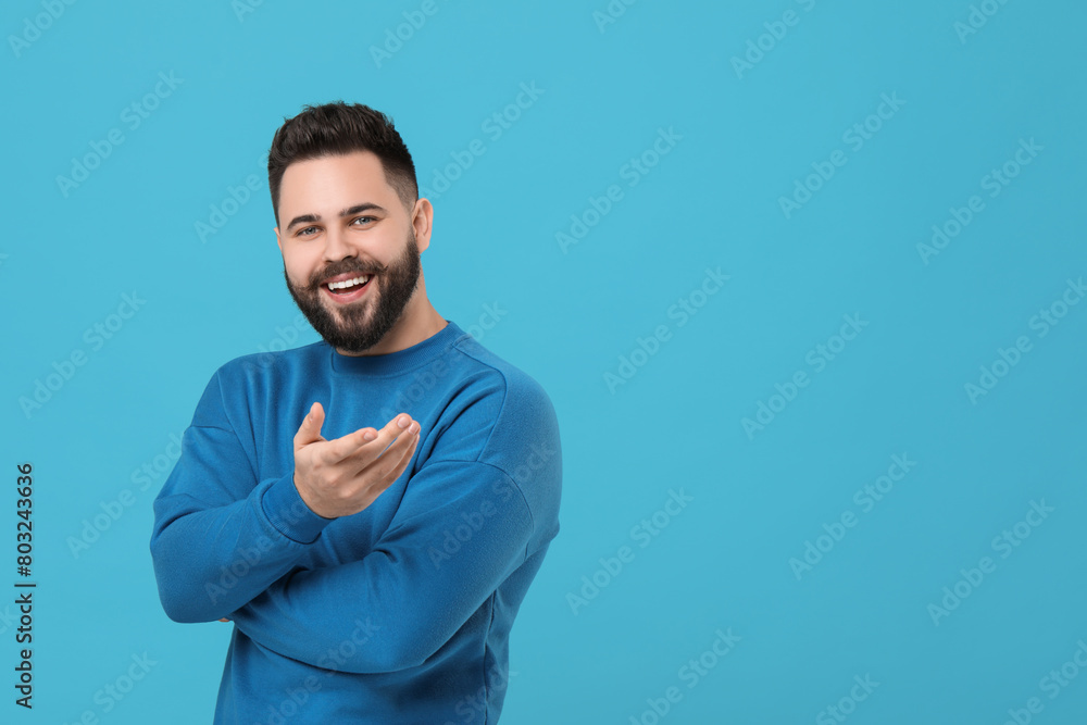 Portrait of happy young man with mustache on light blue background. Space for text Portrait of happy young man with mustache on light blue background. Space for text