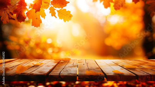 Wooden table in an autumnal setting  foreground focus with a blurred backdrop of warm  glowing fall leaves