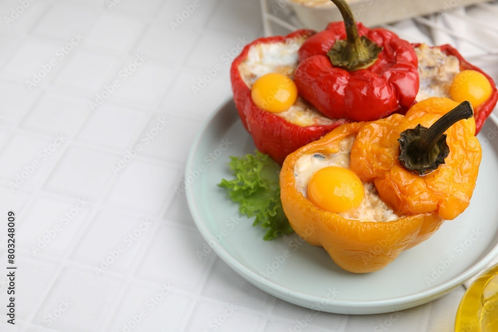 Delicious stuffed bell peppers with fried eggs on white tiled table, space for text Delicious stuffed bell peppers with fried eggs on white tiled table, space for text