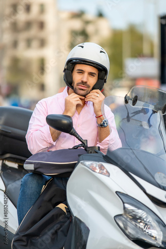 Cosmopolitan attractive man using a scooter motorcycle