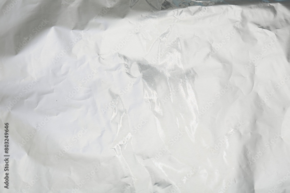 Obraz premium Crumpled silver foil as background, top view