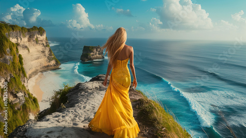 A woman walks along the beach, in front of the ocean